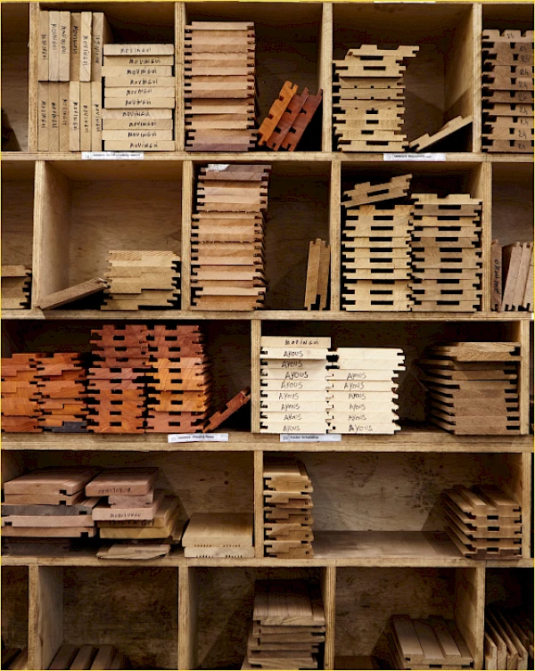 verschillende houtsoorten planken gesorteerd in houten kast